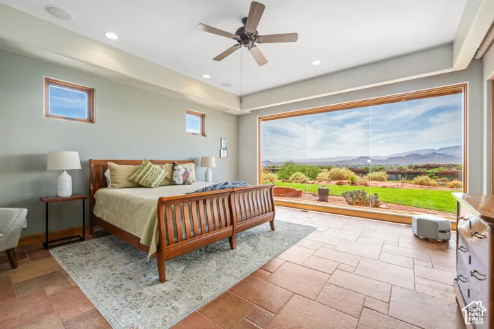 Expansive picture window, recessed lighting, ceiling fan, and tile flooring