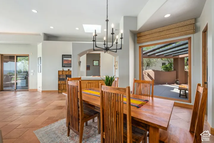 Terracotta-style tile flooring, recessed lighting, skylight, archway entry, and a large picture window with outdoor access