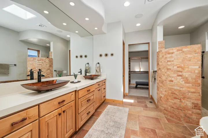 Dual vessel sinks atop an expansive vanity with wood cabinetry