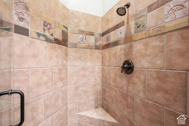 Tiled shower with decorative accent border, corner bench, and oil-rubbed bronze fixtures