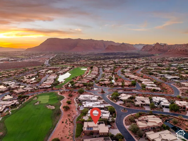 Aerial perspective showcasing a residential community with winding roads, golf course fairways, and natural desert landscaping