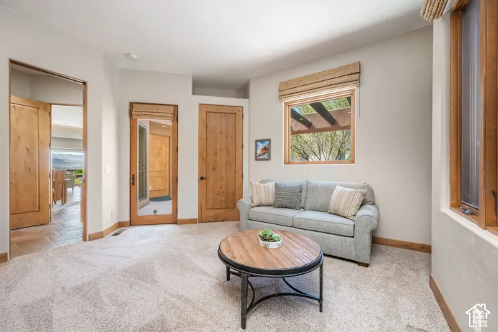 Light-toned wall finishes, light wood-finish doors, carpeted flooring, and a fixed window with wood-finish trim