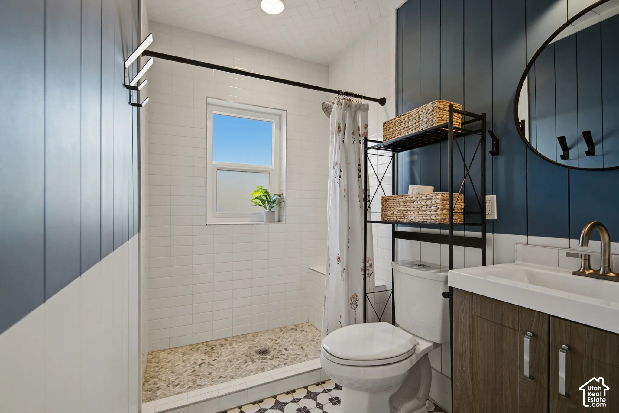 Walk-in shower with pebble tile flooring and white subway tile surround