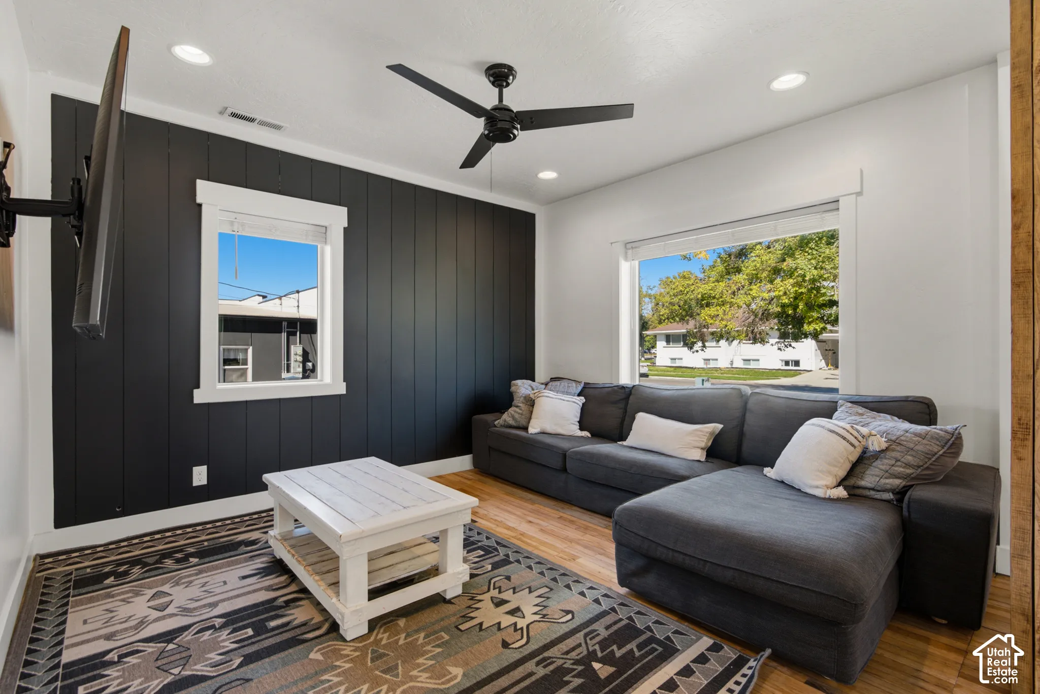 Recessed lighting, wood-finish flooring, ceiling fan, and white trim accents