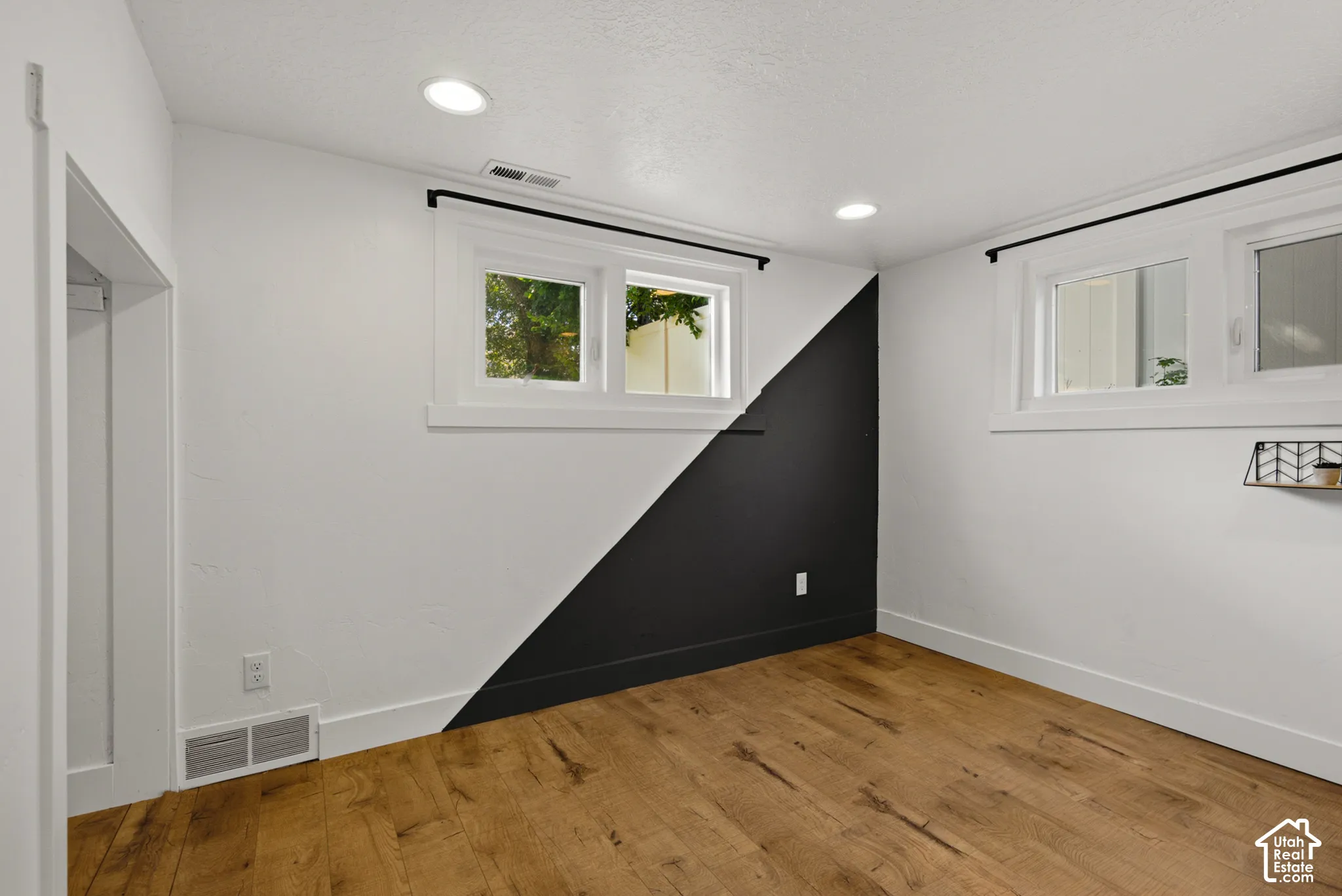 Wood-finish flooring, recessed lighting, and multiple windows