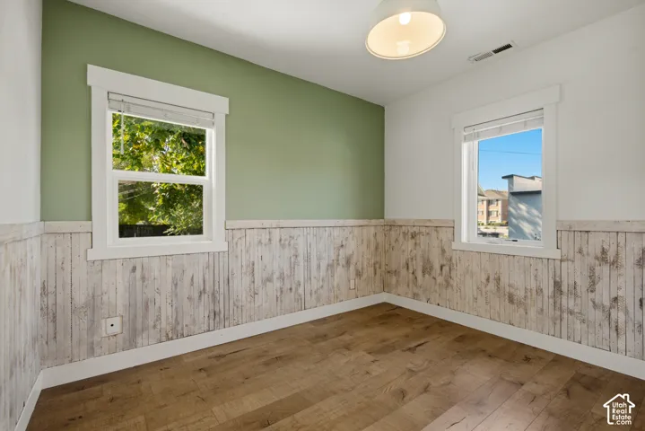 Wood-finish flooring with white trim and distressed wood paneling