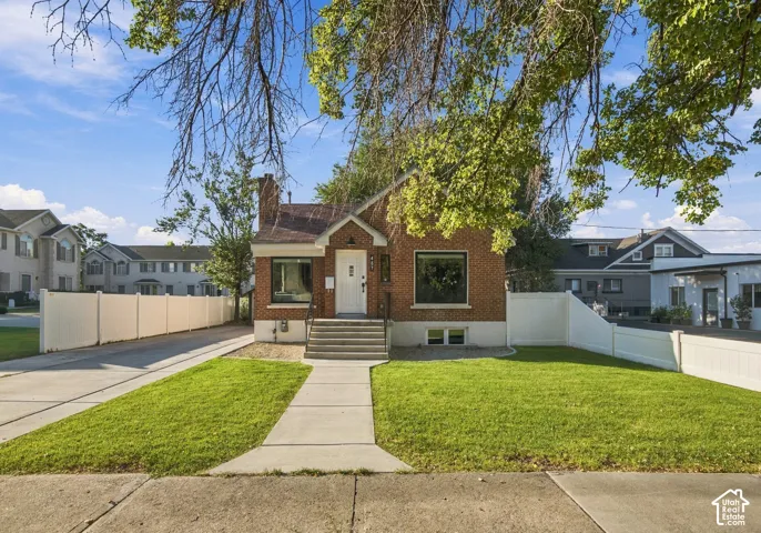 Brick exterior with a white entry door, framed by a concrete walkway and a concrete driveway