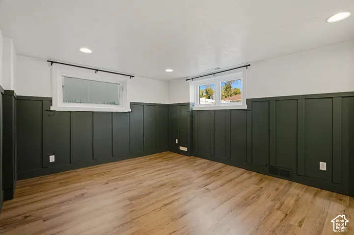Wood-finish flooring, recessed ceiling lighting, board and batten wall detailing, and two windows
