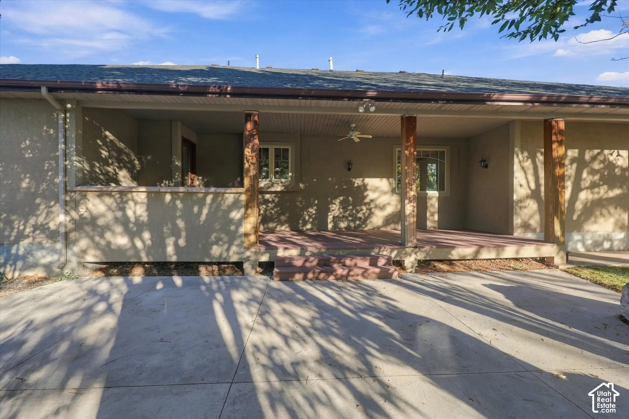 Covered concrete patio featuring timber support posts, a ceiling-mounted fan, recessed exterior lighting, and a concrete slab foundation