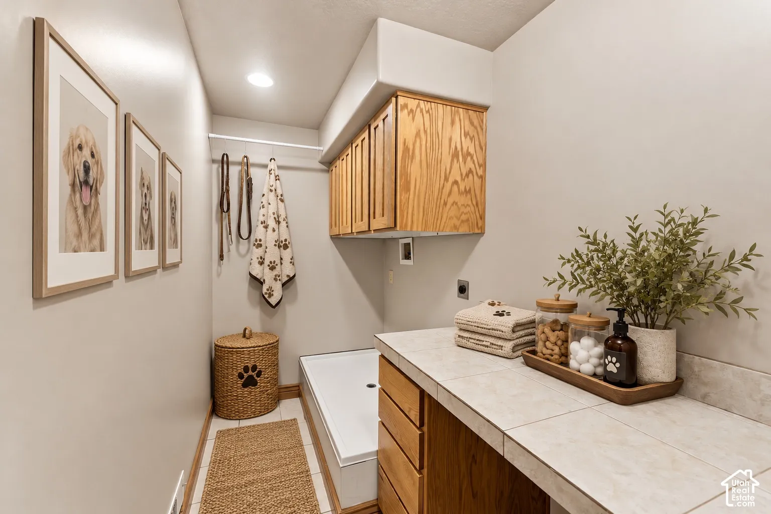 Utility area featuring custom wood cabinetry, tiled countertop, integrated wash basin, and recessed lighting