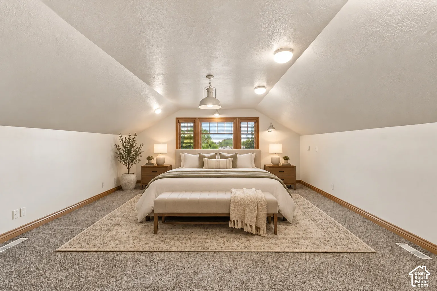 Vaulted ceiling, neutral wall tones, carpeted flooring, and wood-trimmed multi-pane windows