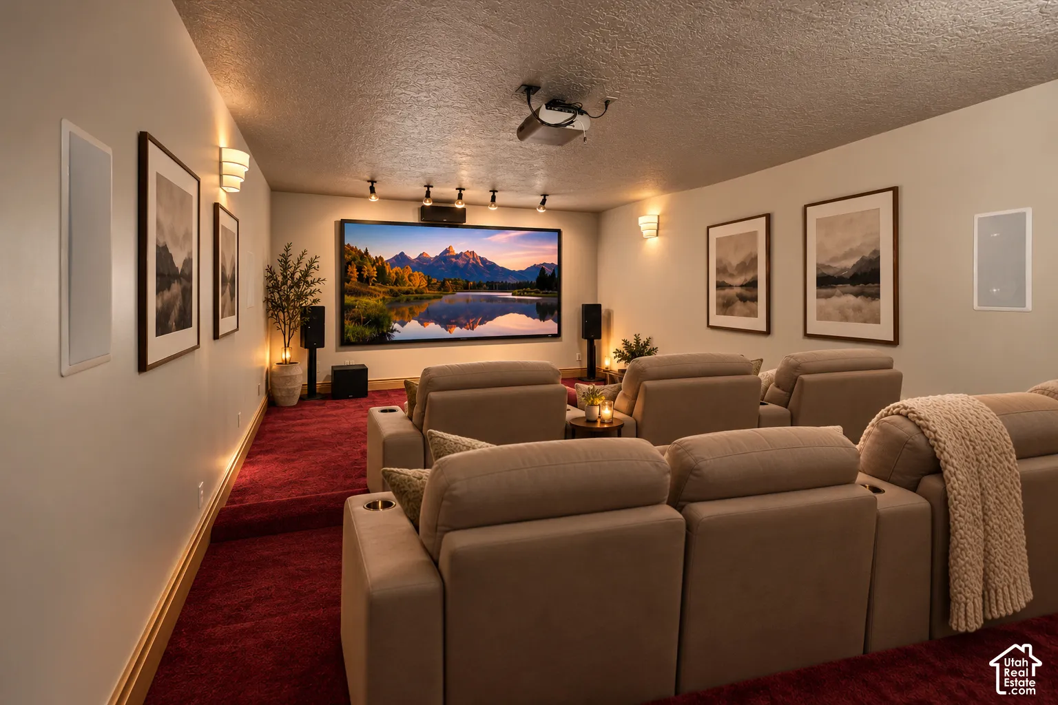 Dedicated media room featuring tiered flooring, wall-mounted screen, ceiling-mounted projector, and integrated wall speakers