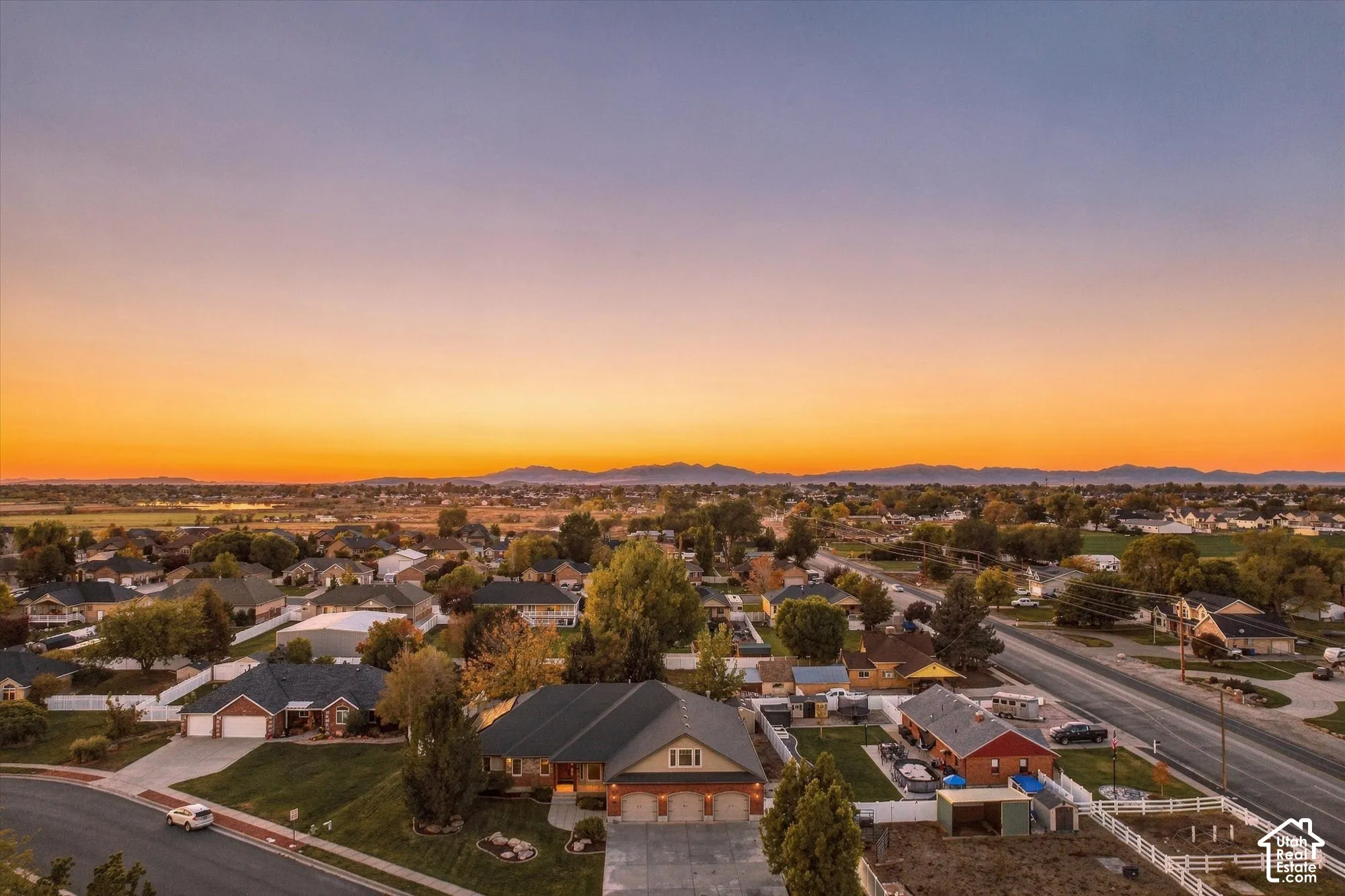 Aerial perspective featuring a multi-gabled roofline, three-car garage, and mountain backdrop