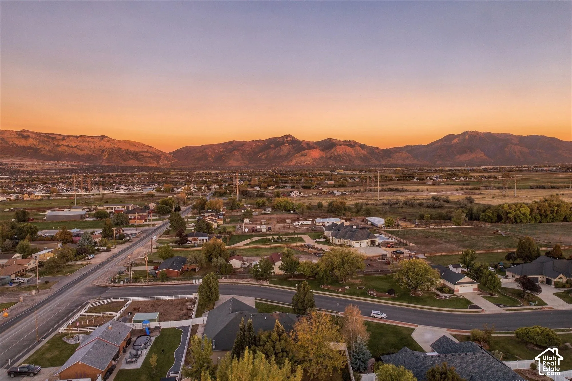 Aerial perspective featuring expansive mountain range backdrop and mature trees