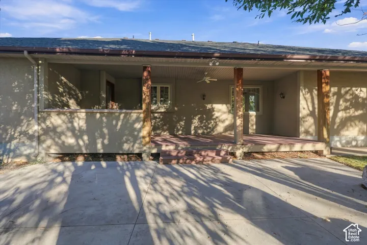 Covered concrete patio featuring timber support posts, a ceiling-mounted fan, recessed exterior lighting, and a concrete slab foundation