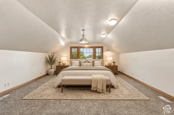 Vaulted ceiling, neutral wall tones, carpeted flooring, and wood-trimmed multi-pane windows