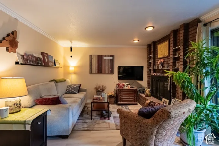Living space featuring crown molding, recessed lighting, and wood-finish flooring