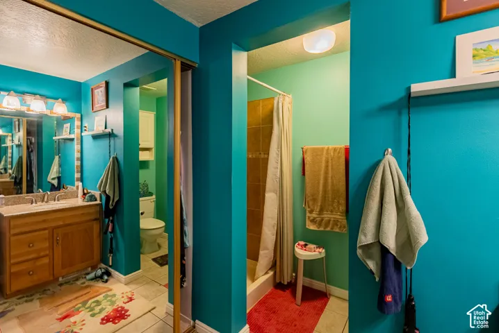 Wood-finish vanity with a single basin, wall-mounted mirror, and vanity lighting