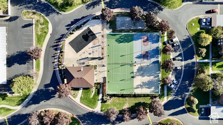 Community recreational area featuring multiple sports courts, a playground, a community building, and paved walking paths