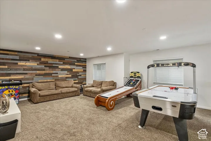 Spacious room featuring a decorative wood-plank accent wall, recessed lighting, and dual windows with horizontal blinds