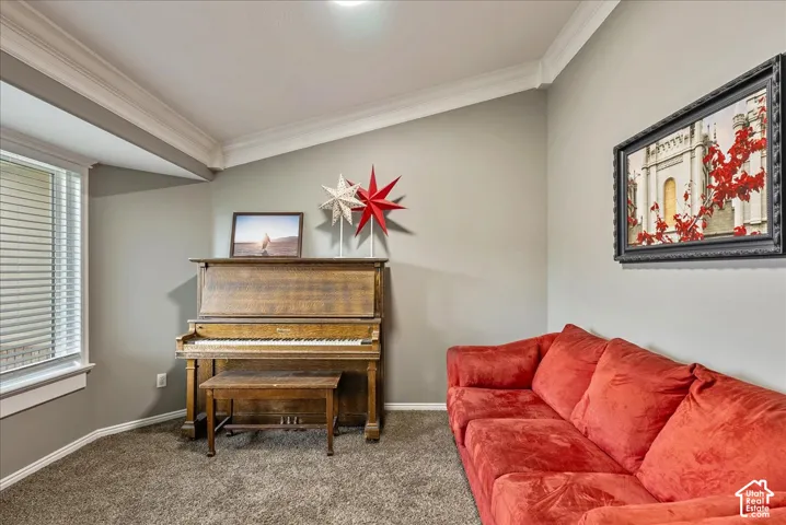 Neutral wall tones featuring vaulted ceilings, crown molding, and large windows with integrated blinds