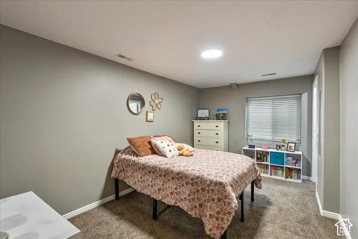 Room featuring neutral wall tones, wall-to-wall carpeting, a recessed ceiling light, and a window with horizontal blinds