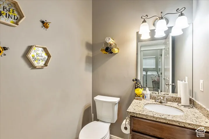 Vanity featuring a stone-composite countertop with an integrated basin, dark wood cabinetry, a three-light fixture, and a large wall-mounted mirror