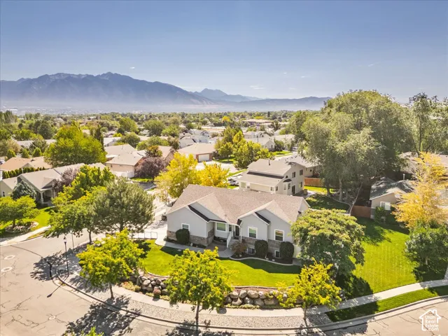 Stunning aerial view showcasing this single-story residence set on a generous lot with mature landscaping, manicured lawn, and established trees