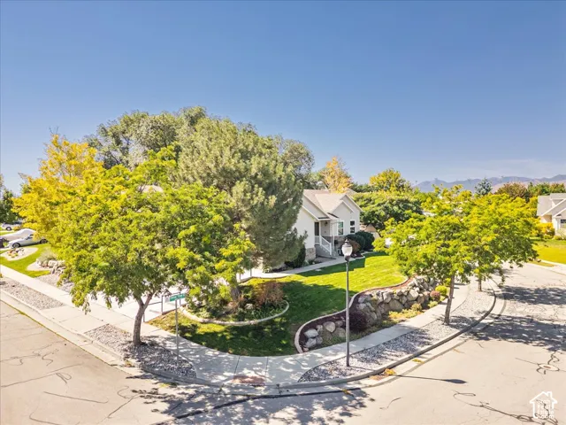 Mature shade trees frame this charming single-story residence set on a generous lot with expansive manicured lawn