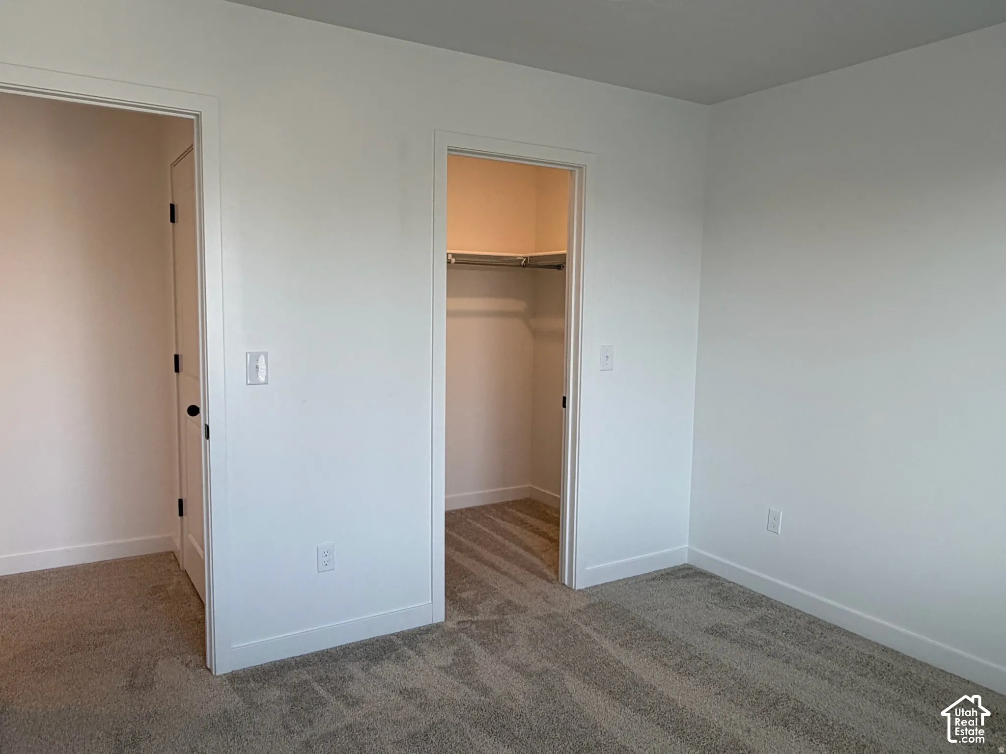 Bedroom #2 Plush carpet flooring, white painted walls, and a built-in closet with shelving and hanging rod