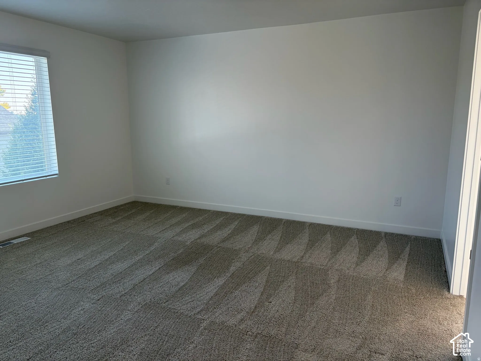 Owner's suite with Neutral wall paint, plush carpet flooring, window with horizontal blinds
