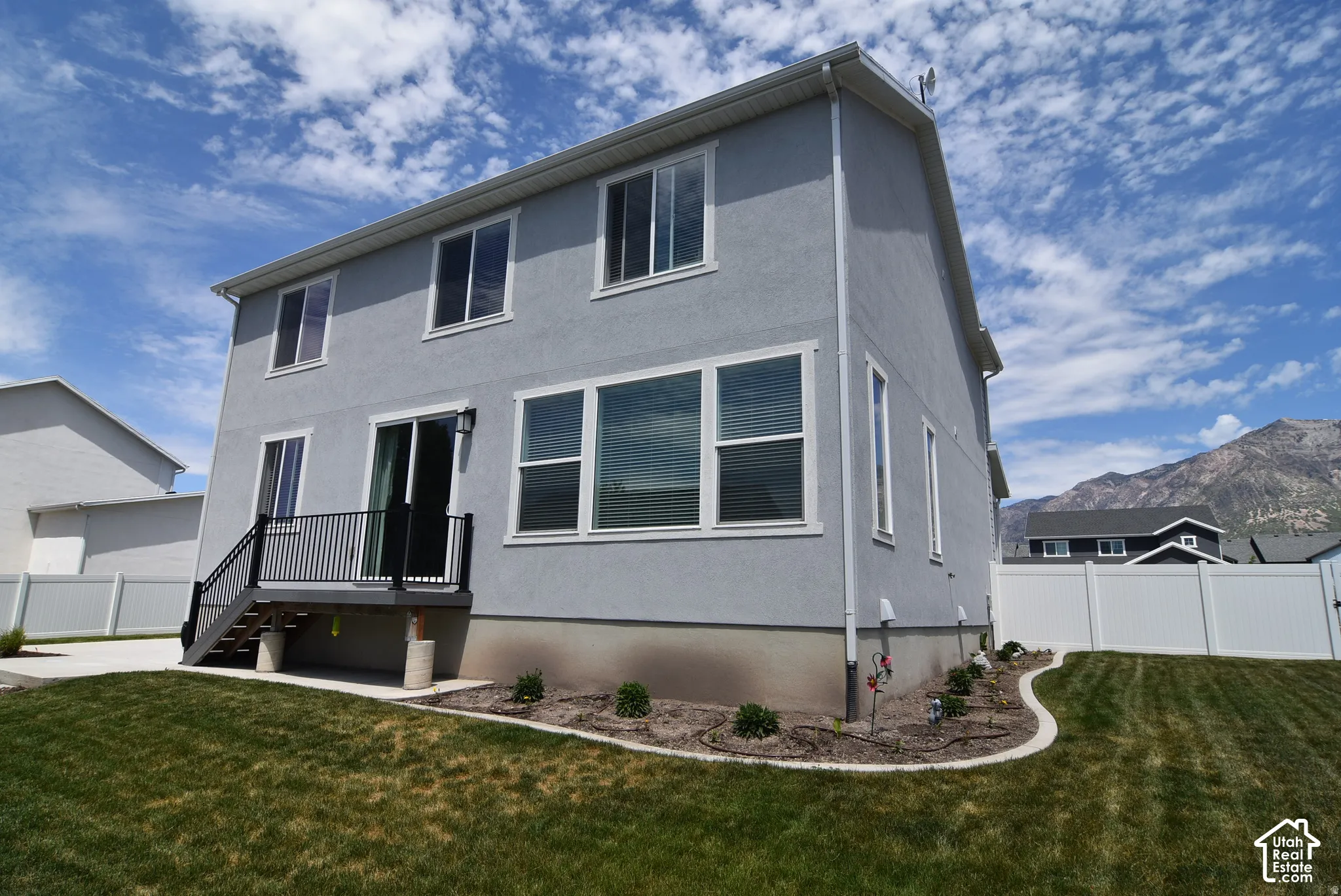 Two-story residence featuring light gray stucco siding and white trim