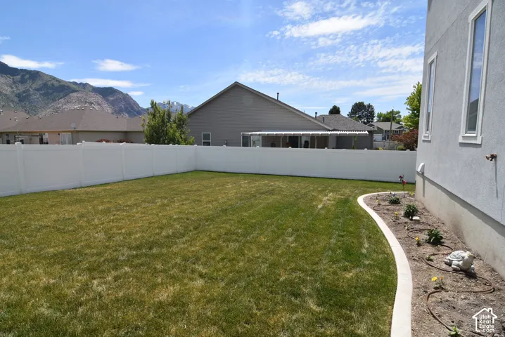 Expansive green lawn with a white privacy fence
