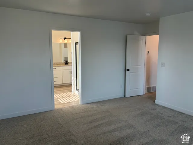 Owner's suite Plush carpeting, modern interior doors, and a bathroom featuring a dual vanity with a granite-style countertop and wood-finish flooring