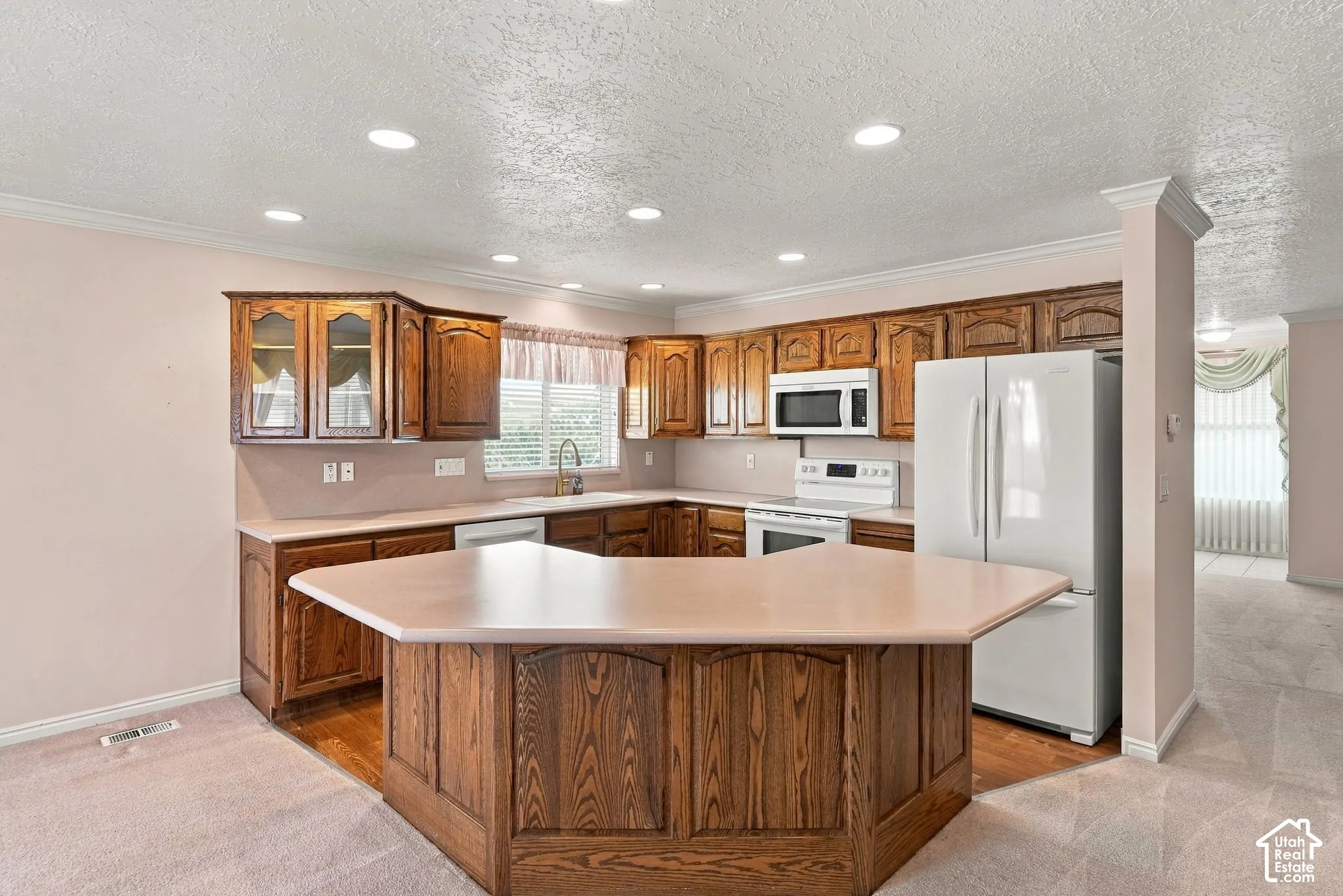 Kitchen featuring wood cabinetry, a central island with countertop, and recessed lighting