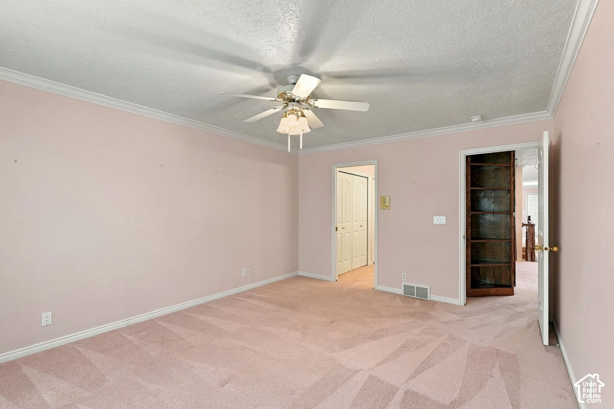 Wall-to-wall carpeting, crown molding, and a ceiling fan with integrated lighting