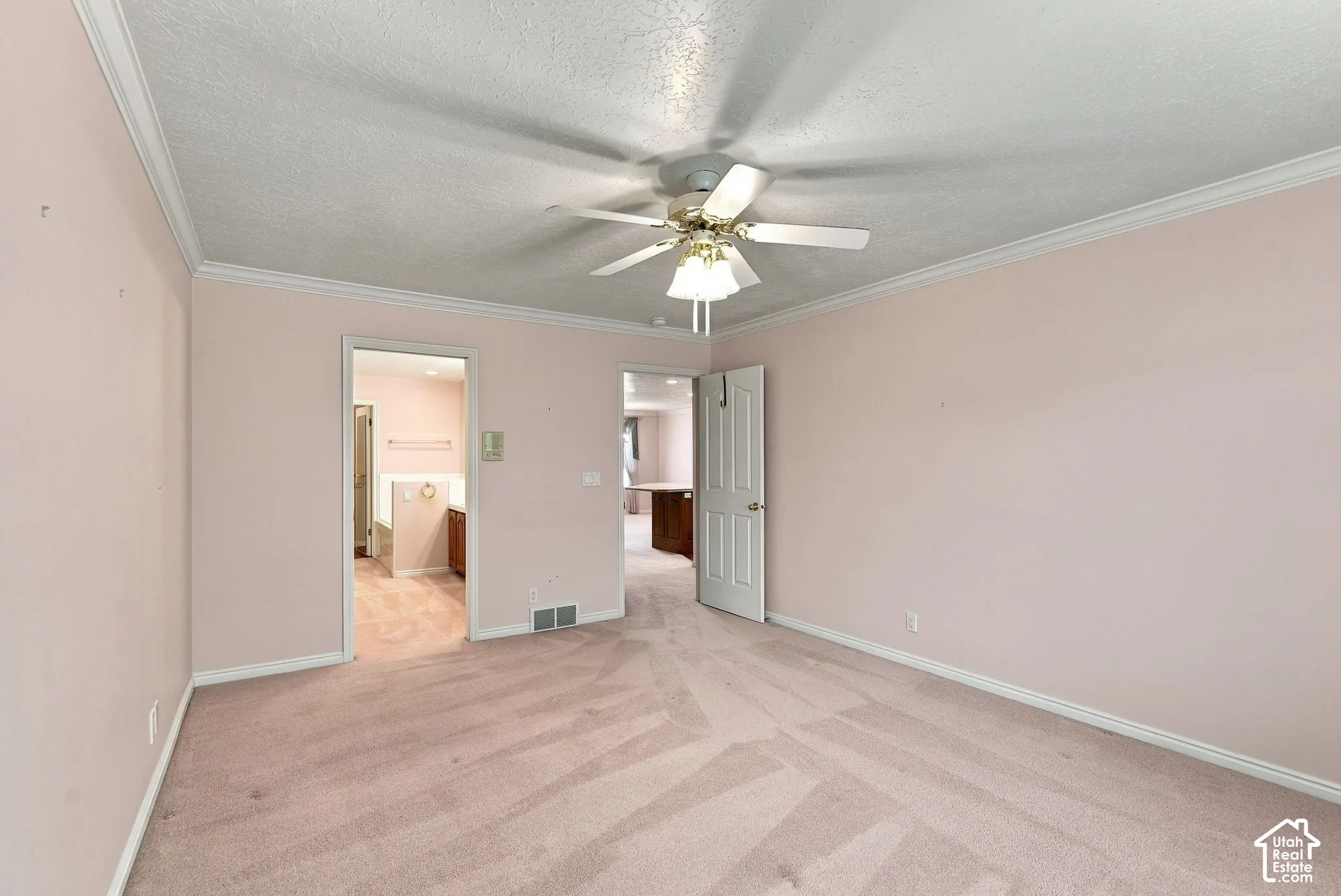 Wall-to-wall carpeting, ceiling fan with integrated lighting, and crown molding