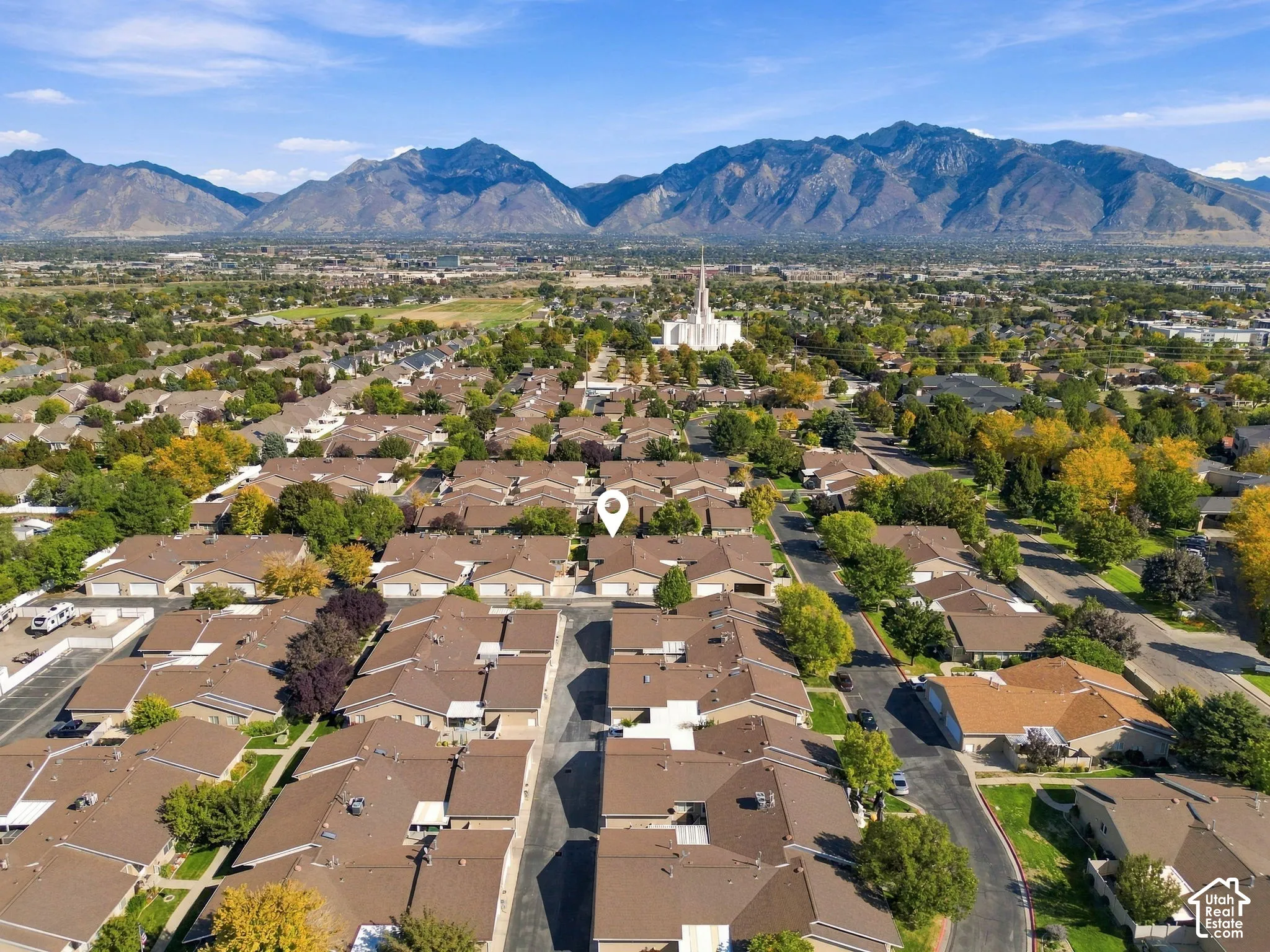 Mountain backdrop, expansive residential area, mature trees, multi-unit properties, paved roadways