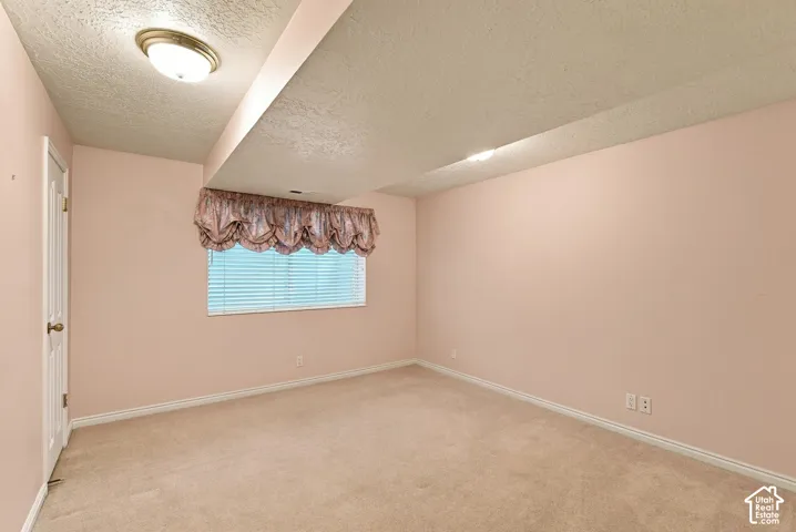 Carpeted flooring, recessed lighting, and a single window with blinds