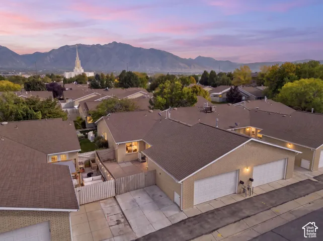 Townhome community with attached garages, private patios, and a mountain backdrop