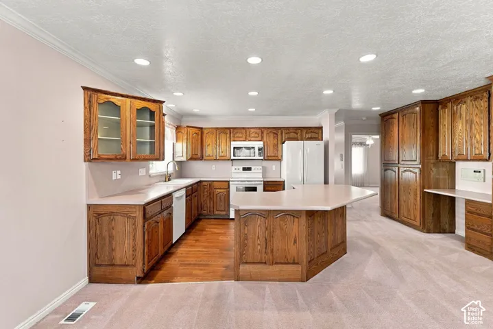 Kitchen featuring wood cabinetry, solid surface countertops, a center island, recessed lighting, and integrated appliances