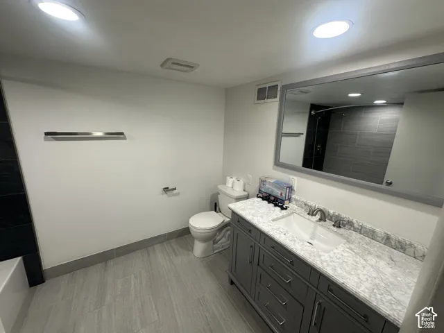 Vanity with a white sink, brushed nickel faucet, and a stone countertop