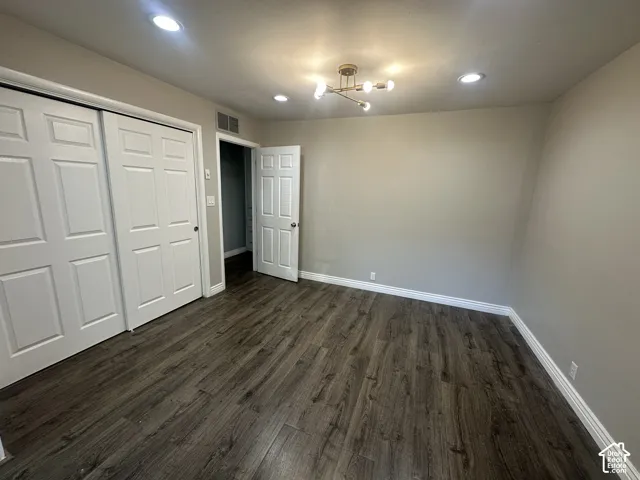 Wood-finish flooring, recessed lighting, contemporary ceiling light fixture, bi-fold closet doors, and a paneled interior door
