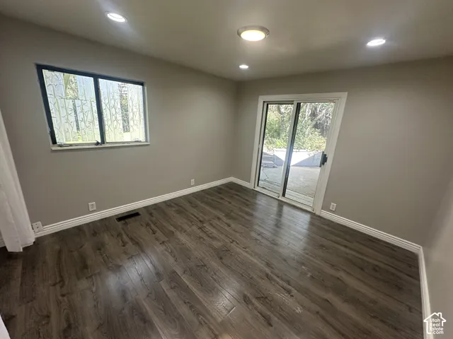 Wood-finish flooring, recessed lighting, and a sliding glass door