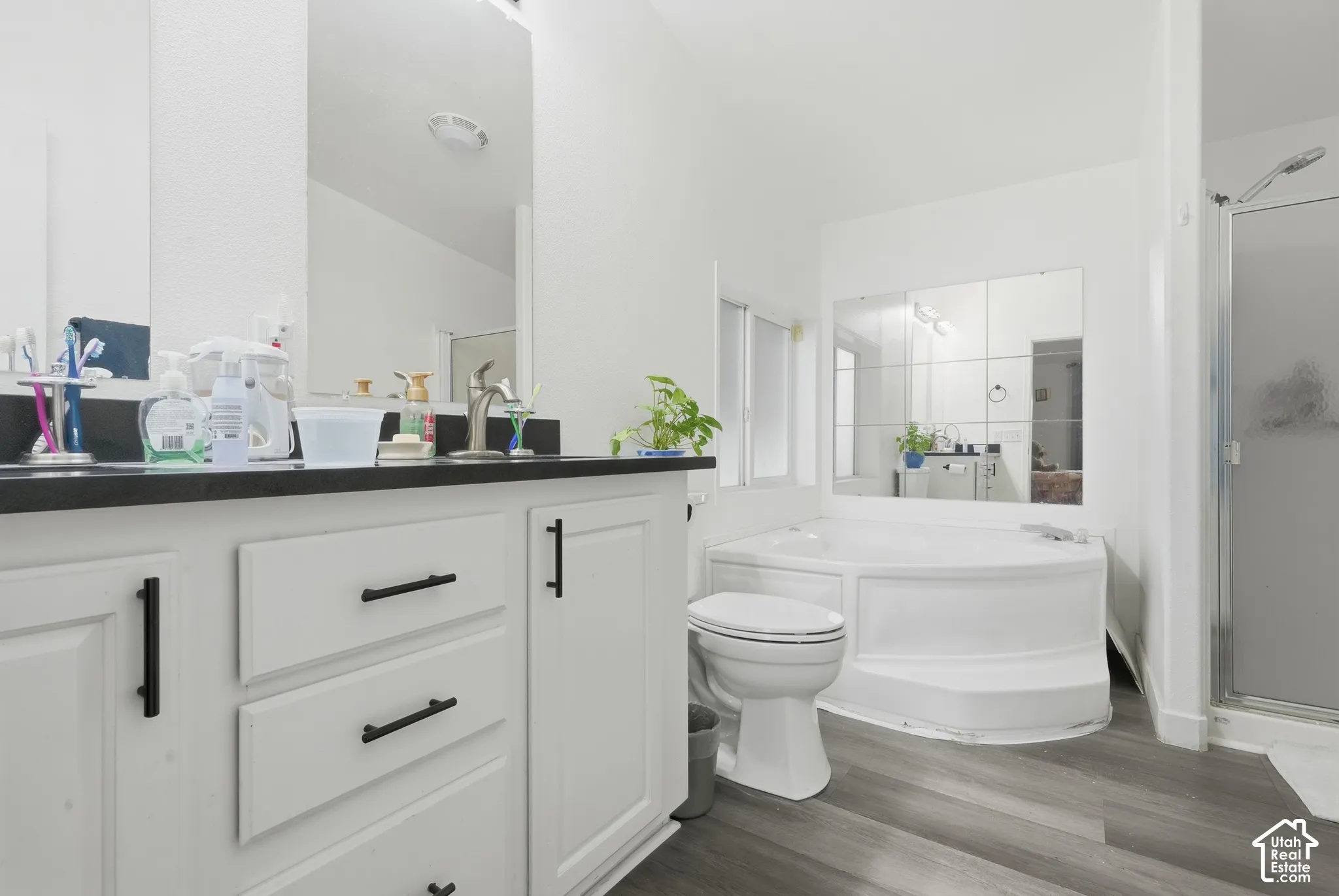 Dual vanity with dark countertops, white cabinetry, and matte black hardware
