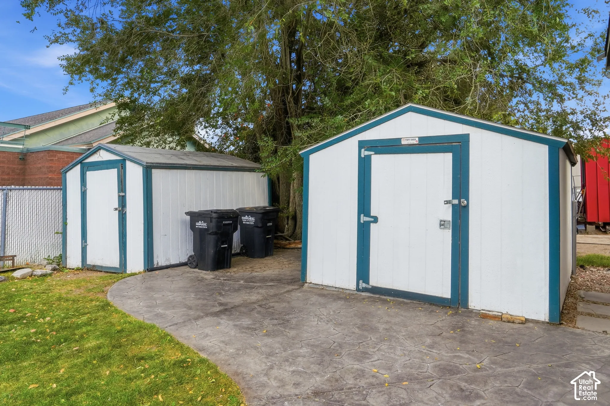 Two storage sheds with white siding and blue trim
