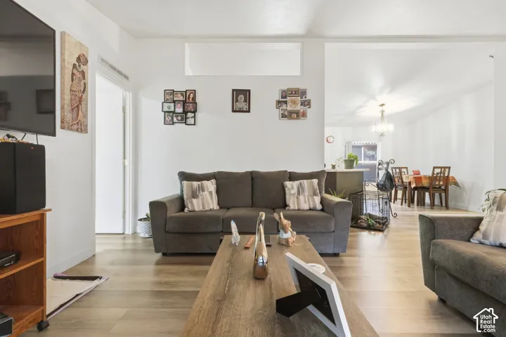 Wood-finish flooring throughout, white painted walls, and open archway to dining area