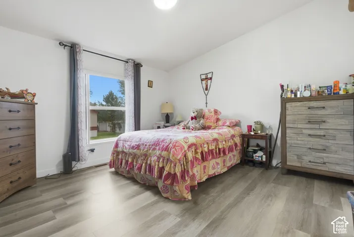 Light wood-finish flooring, white walls, and a window with exterior visibility