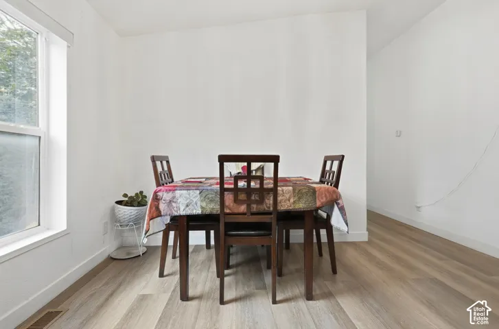 Wood-finish flooring with white baseboards and a double-hung window