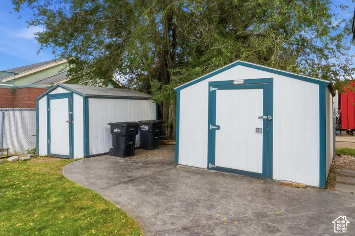 Two storage sheds with white siding and blue trim